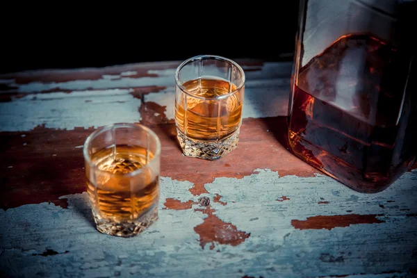 Two glasses of whiskey vintage photo, a bottle on the bar — Stock Photo, Image