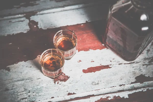 Two glasses of whiskey vintage photo, a bottle on the bar — Stock Photo, Image