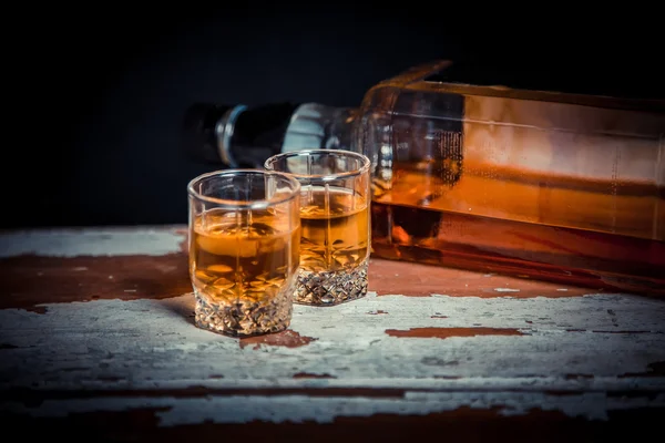 Two glasses of whiskey vintage photo, a bottle on the bar — Stock Photo, Image