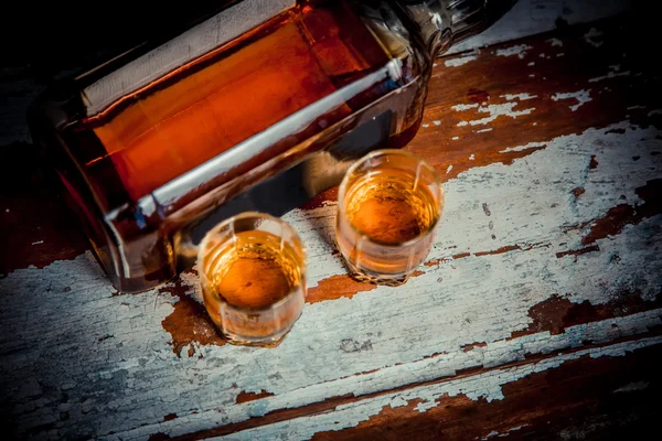 Two glasses of whiskey vintage photo, a bottle on the bar — Stock Photo, Image