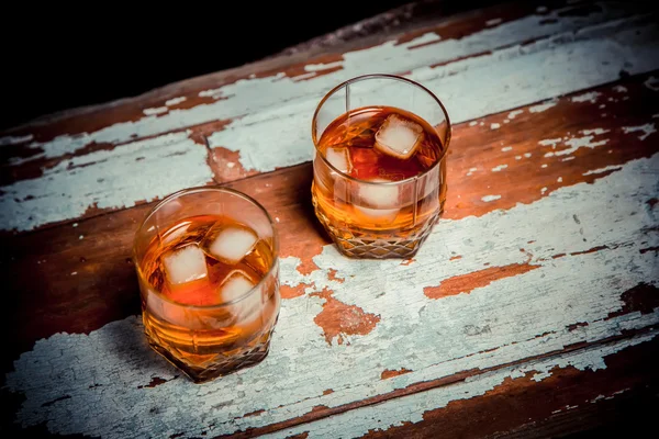 Two glasses of whiskey vintage photo, a bottle on the bar — Stock Photo, Image