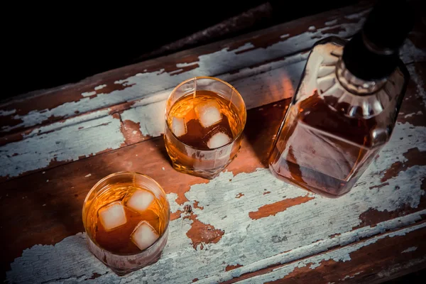 Two glasses of whiskey vintage photo, a bottle on the bar — Stock Photo, Image