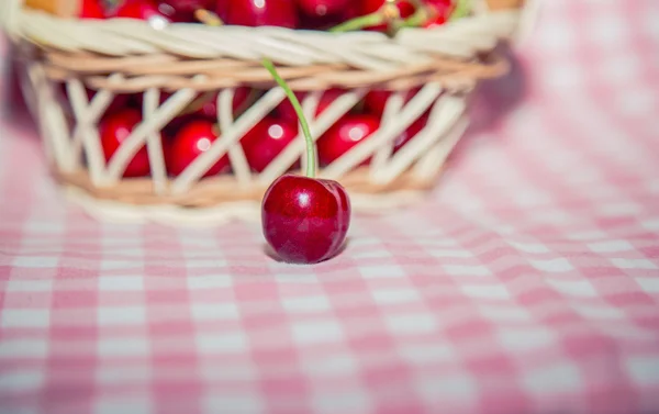 Cereja em um contexto de cerejas em uma cesta — Fotografia de Stock