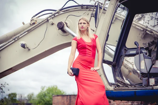 La rubia en un vestido rojo en la excavadora, moda de belleza, otoño — Foto de Stock