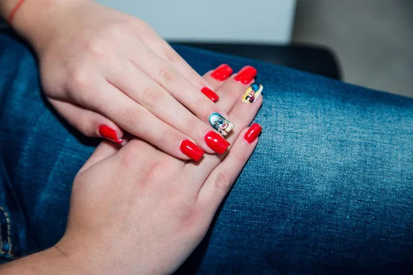 Manicura roja, manicura en las manos, fondo vaquero —  Fotos de Stock