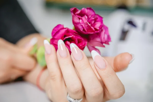 Eleganta manikyr på en bakgrund av blommor, skönhetssalong — Stockfoto