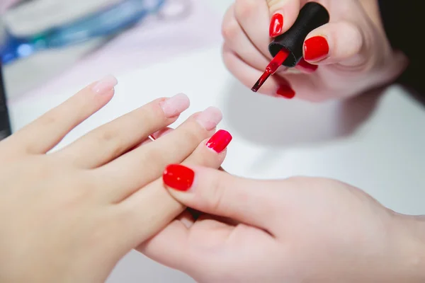 Pintura laca uñas rojas en salón de belleza — Foto de Stock