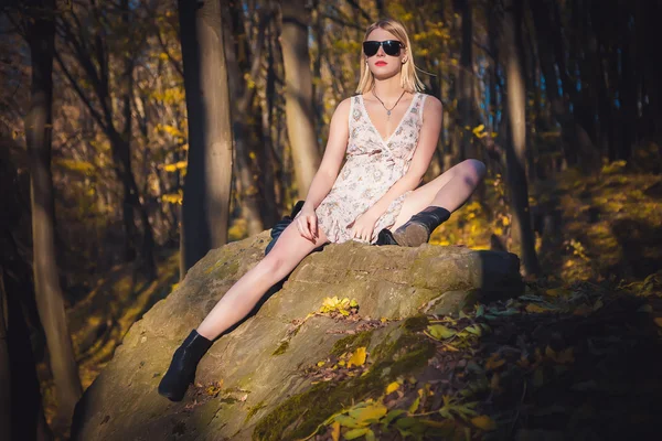 Sexy chica acostada en una roca en el bosque, ropa de publicidad —  Fotos de Stock