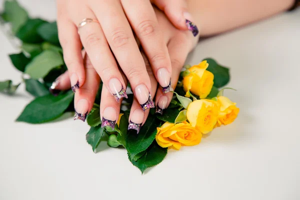 Kobiece Manicure, manicure na tle kwiatów — Zdjęcie stockowe