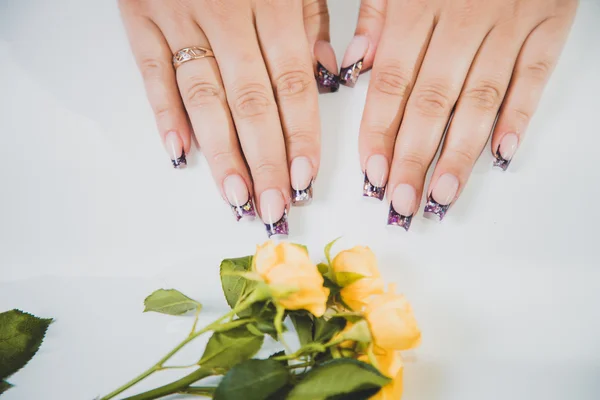 Manicure femminile, manicure su uno sfondo di fiori — Foto Stock