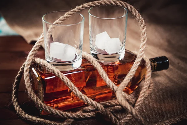 Whiskyglas mit Eis, einer Flasche Whisky und einem Seil — Stockfoto