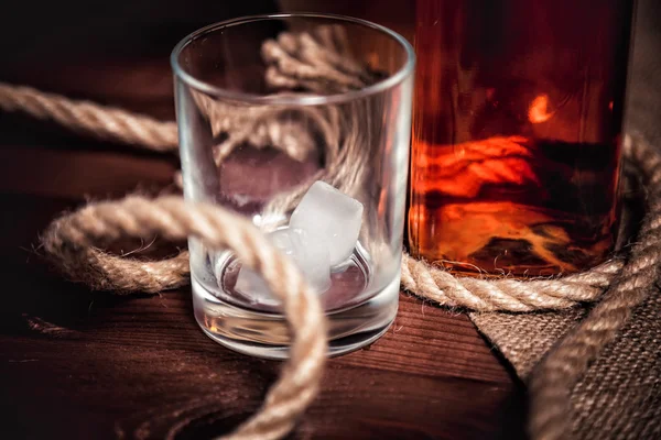 Whiskyglas mit Eis, einer Flasche Whisky und einem Seil — Stockfoto