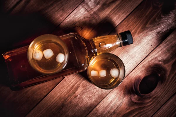 Стакан виски со льдом, бутылка односолодового виски — стоковое фото