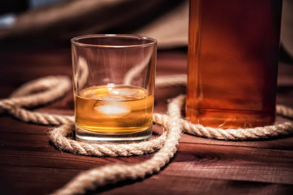 Pohár whiskyt jéggel, egy üveg whiskyt elfogyasszon — Stock Fotó