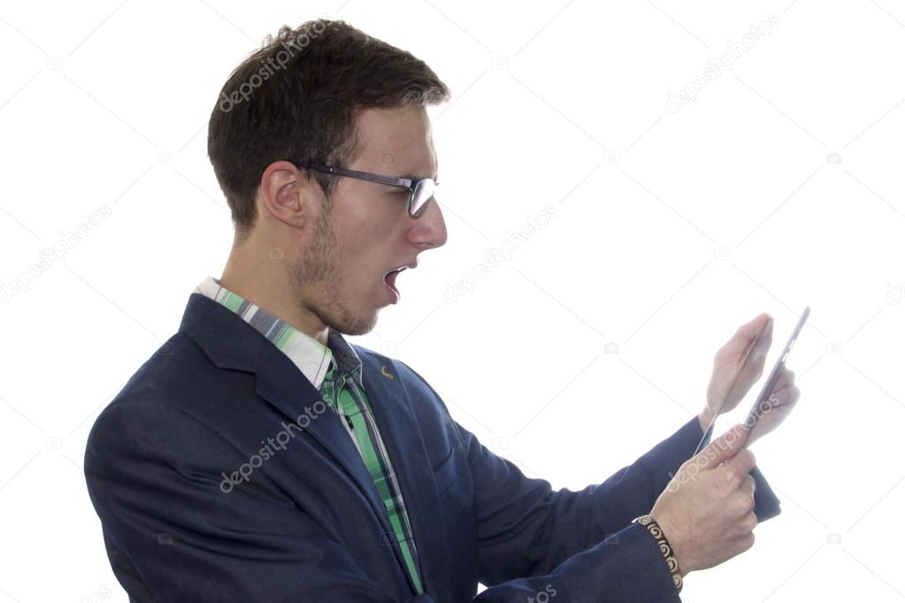 Outraged young handsome man holding a tablet or ipad