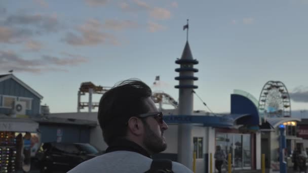 Santa Monica Pier blured people in background, uomini che camminano in slow motion camera avanti epico tempo del tramonto — Video Stock