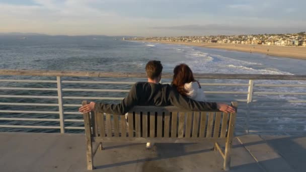 Pareja en Hermosa Beach Pier famosa escenaria La La Land, disfrutando de una hermosa vista del océano con destellos de sol — Vídeos de Stock