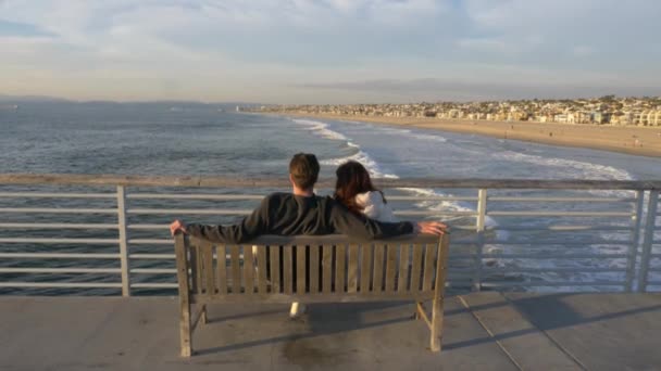 Пара на пирсе Эрмоса Бич знаменитый сценарий La La La Land, открывается прекрасный вид на океан с солнечной вспышкой — стоковое видео
