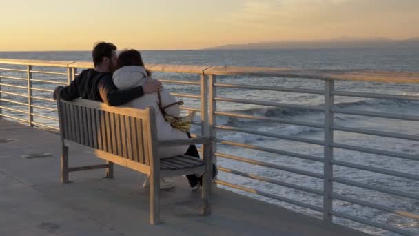 ヘルモサビーチ桟橋のカップルの男性と女性有名なラ・ラ・ランドの風景、太陽のフレアで海の美しい景色を楽しむ — ストック動画