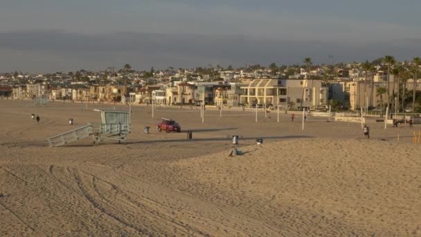 Hermosa Beach California USA - Enero 2020 Coche de rescate rojo con tabla de surf en Tam en Sandy Beach con campos de voleibol — Vídeos de Stock