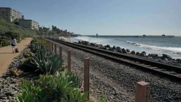 Starsza dojrzała kobieta jedzie pociągiem na tory kolejowe piękny krajobraz Pacyficzne wybrzeże Orange County San Clemente — Wideo stockowe