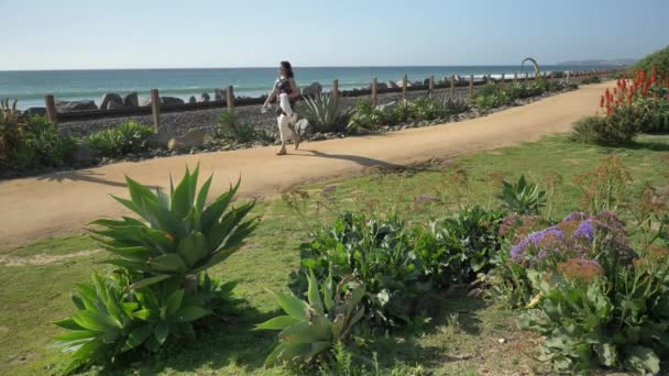 Senior mature woman walking happy at the trail close to railroad track beautiful landscape pacific coast Orange county San Clemente — Stock Video