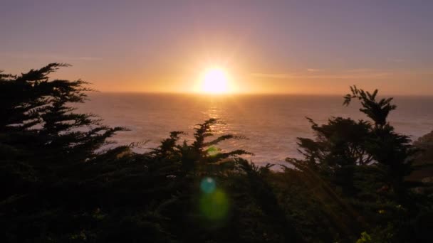 Rosa und lila Sonnenuntergang an der malerischen Big Sur Küste des Pazifischen Ozeans mit wunderschönen Bäumen — Stockvideo