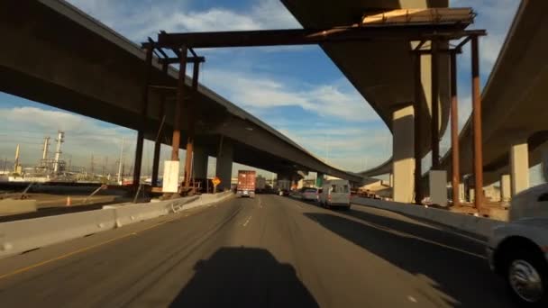 Long Beach California EUA - janeiro de 2020. Condução através da construção industrial perto do porto com céu azul bonito e nuvens — Vídeo de Stock