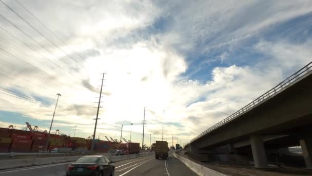 Long Beach California EUA - janeiro de 2020. Condução de grandes caminhões recipiente com céu azul bonito e nuvens — Vídeo de Stock