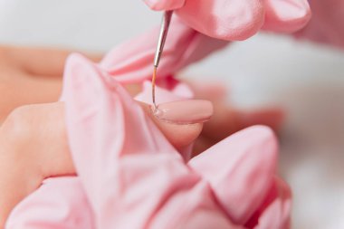 Manikür işlemi. Manikürcü oje sürüyor. Tırnak cilası..