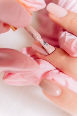 Manikür işlemi. Manikürcü oje sürüyor. Tırnak cilası..