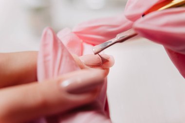 Manikür işlemi. Manikürcü oje sürüyor. Tırnak cilası..