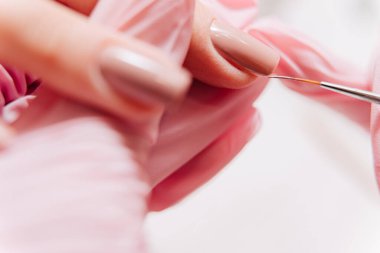 Manikür işlemi. Manikürcü oje sürüyor. Tırnak cilası..