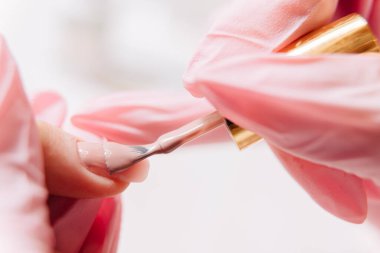 Manikür işlemi. Manikürcü oje sürüyor. Tırnak cilası..