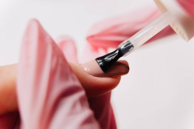 Manikür işlemi. Manikürcü oje sürüyor. Tırnak cilası..