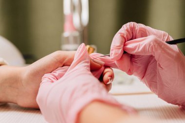 Manikür işlemi. Manikürcü oje sürüyor. Tırnak cilası..