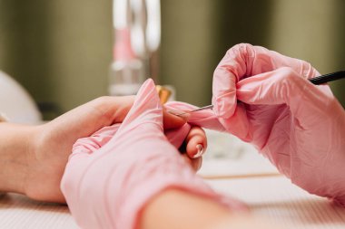 Manikür işlemi. Manikürcü oje sürüyor. Tırnak cilası..