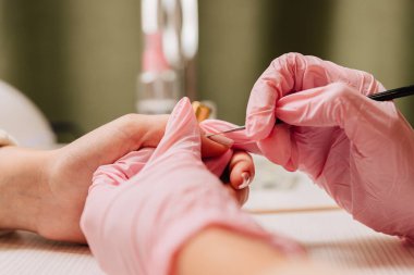 Manikür işlemi. Manikürcü oje sürüyor. Tırnak cilası..