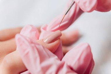Manikür işlemi. Manikürcü oje sürüyor. Tırnak cilası..