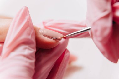 Manikür işlemi. Manikürcü oje sürüyor. Tırnak cilası..