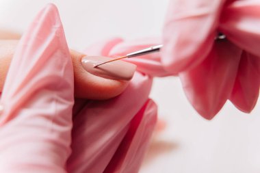 Manikür işlemi. Manikürcü oje sürüyor. Tırnak cilası..