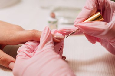 Manikür işlemi. Manikürcü oje sürüyor. Tırnak cilası..