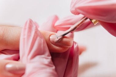 Manikür işlemi. Manikürcü oje sürüyor. Tırnak cilası..