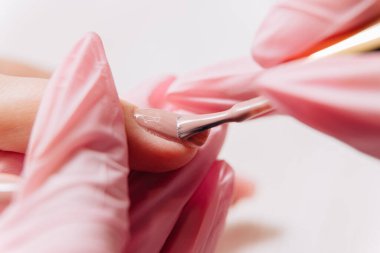 Manikür işlemi. Manikürcü oje sürüyor. Tırnak cilası..