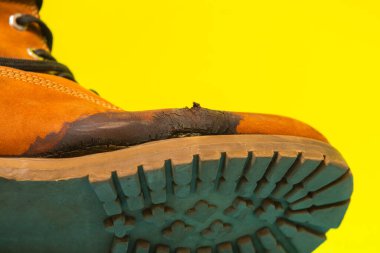 Mahvolmuş bir ayakkabı. Ayakkabının yüzeyinde çatlak ve lekeler var..