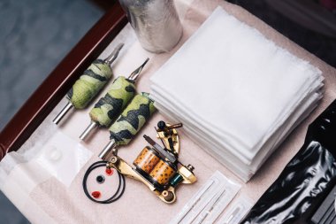 Dövme sanatçıları için bir takım aletler. İğneler, peçeteler, dövme makinesi, değiştirilebilir kulplar..