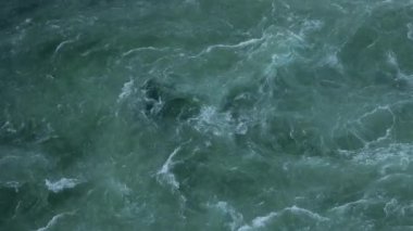 Bir kuşun gözünden suyun yüzeyi. Bulutlu bir günde sallanan dalgalar.