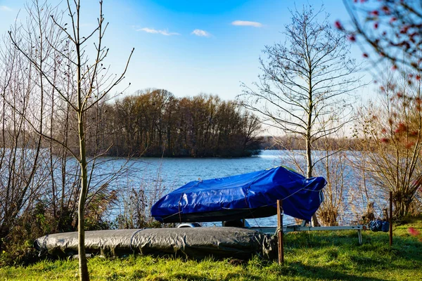 湖の岸に青いタープで覆われたボート 秋の晴れた日 — ストック写真