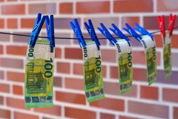 100 euro 'luk banknotlar duvara karşı bir iple kurutuluyor. Mavi mandallar..