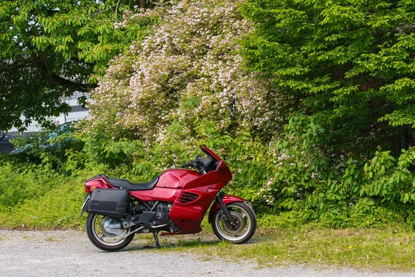 Une Moto Rouge Vif Debout Sur Fond Arbres Verts Fleuris — Photo